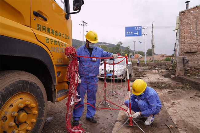 應(yīng)急保電人員正在為電源車裝設(shè)網(wǎng)圍欄。王國棟攝