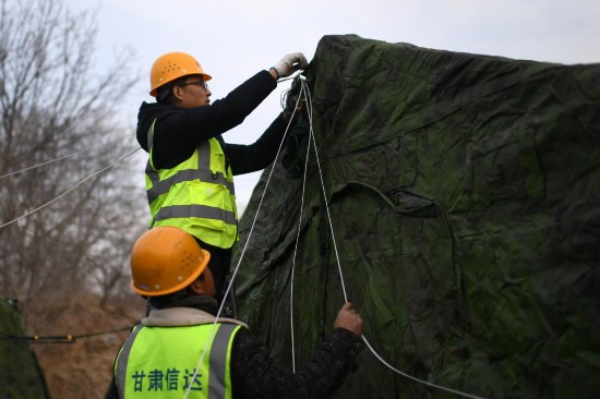 12月20日，甘肅省臨夏州積石山縣大河家鎮(zhèn)大河村集中安置點(diǎn)，工作人員在布設(shè)無(wú)線網(wǎng)絡(luò)。人民網(wǎng)記者 翁奇羽攝